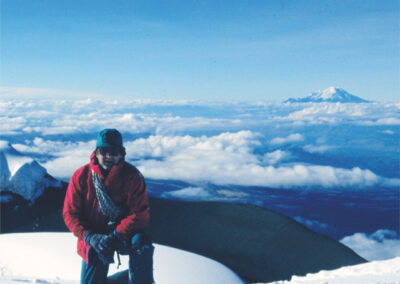 E- Ecuador. I went there to climb volcanoes. This is me on the summit of Cotapaxi 5897m. In the background is Chimborazo 6310m, the highest point of the Andes in Ecuador.